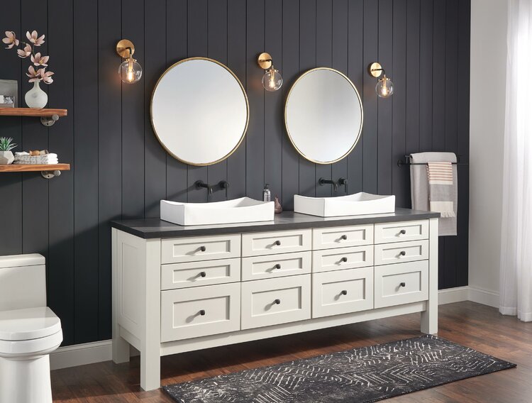 ванная комната с черной деревянной стеной, двумя раковинами и круглыми зеркалами