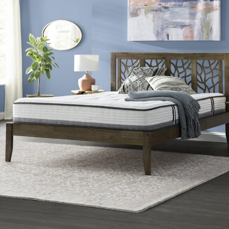 серо-голубая спальня с деревянной кроватью с резным изголовьем и абстрактным панно над ним.jpg
