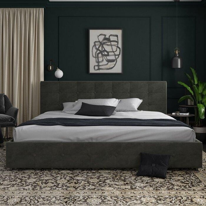 темно-серая кровать с мягким изголовьем в спальне с темно-зелеными стенами и разными светильниками по сторонам кровати.jpeg