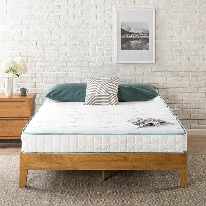 спальня с деревянной кроватью, белой кирпичной стеной и циновкой на полу.jpeg