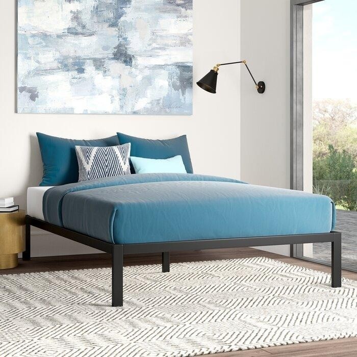 бежево-серо-голубая спальня с черным металлическим основанием вместо кровати и черным светильником.jpeg