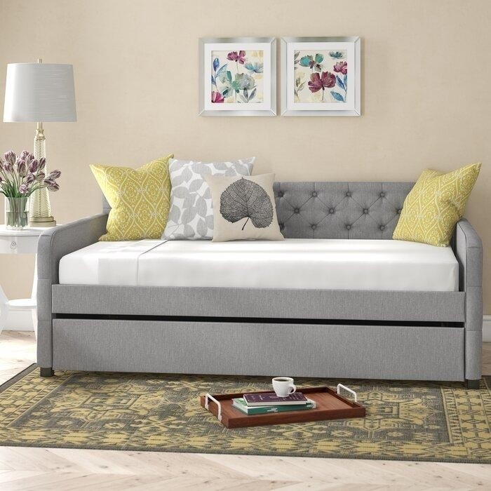серая мягкая софа-кровать с яркими желтыми акцентными подушками.jpeg