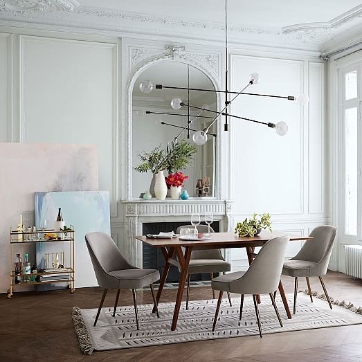 белая классическая гостиная с лепниной и высокими потолками, камином, деревянным столом и серыми мягкими стульями.jpg